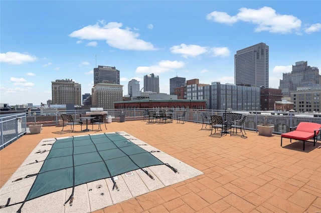 community pool with a skyline view, a patio, and fence
