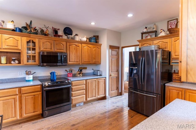 13112 Heritage Ln, Pocahontas, IL 62275 - kitchen featuring appliances with stainless steel finishes, light countertops, light wood-style floors, recessed lighting, and glass insert cabinets