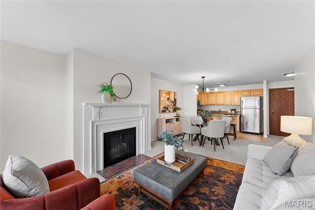 950 E Rue De La Banque Unit 110, Creve Coeur, MO 63141 - living room featuring a fireplace with flush hearth, a chandelier, and light tile patterned flooring