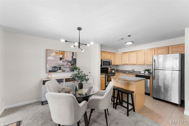 950 E Rue De La Banque Unit 110, Creve Coeur, MO 63141 - kitchen featuring appliances with stainless steel finishes, a sink, light brown cabinets, a chandelier, and a center island