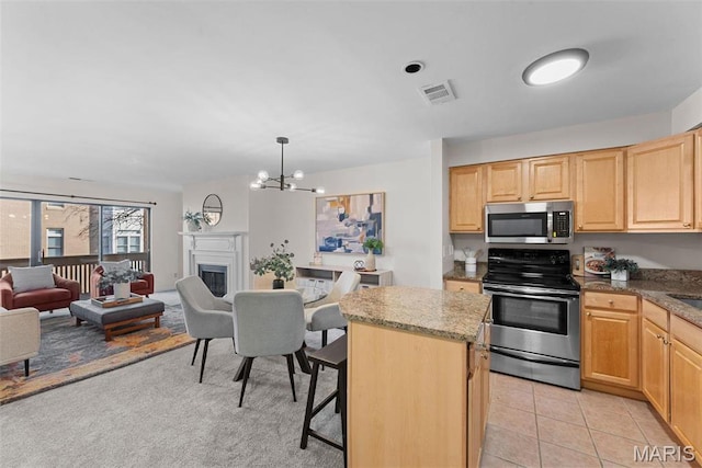 950 E Rue De La Banque Unit 110, Creve Coeur, MO 63141 - kitchen featuring stainless steel appliances, light brown cabinets, open floor plan, and a center island