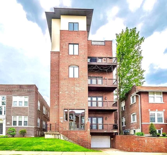 view of apartment building / complex featuring an attached garage and concrete driveway