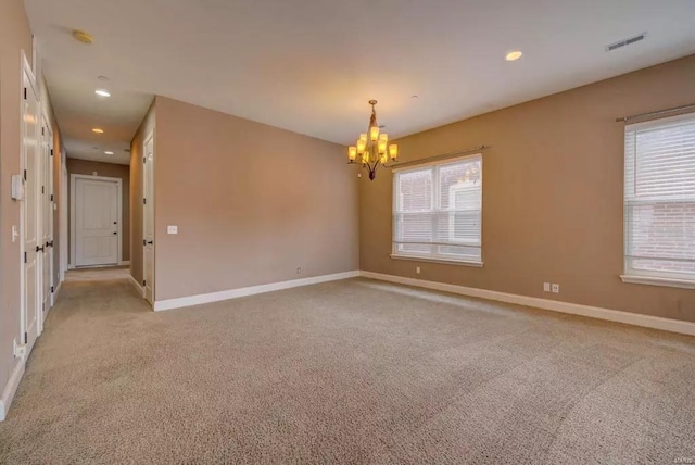 empty room with a chandelier, light carpet, baseboards, and recessed lighting