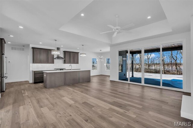 600 Legacy Dr, Waterloo, IL 62298 - kitchen with wall chimney exhaust hood, open floor plan, a raised ceiling, dark brown cabinets, and recessed lighting