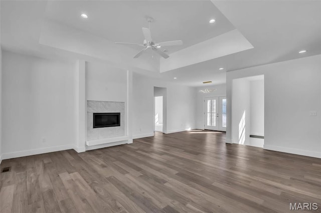 600 Legacy Dr, Waterloo, IL 62298 - unfurnished living room with a raised ceiling, wood finished floors, a glass covered fireplace, recessed lighting, and a ceiling fan