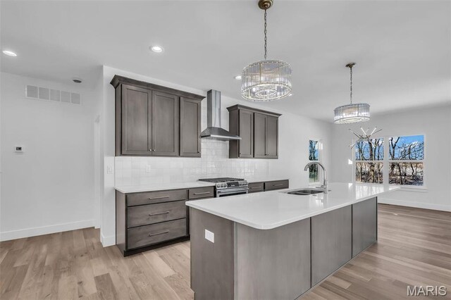 600 Legacy Dr, Waterloo, IL 62298 - kitchen with wall chimney exhaust hood, a sink, gas stove, a chandelier, and recessed lighting
