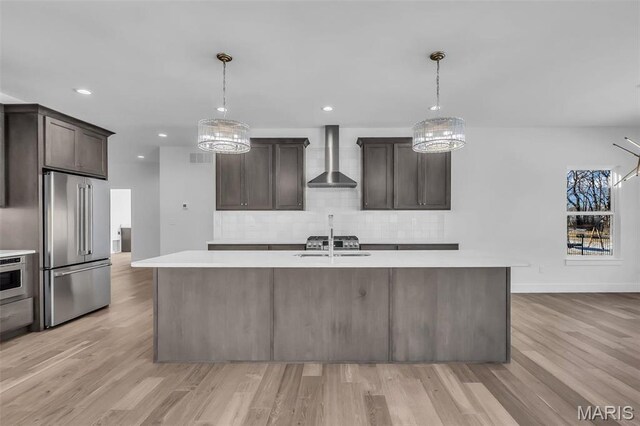 600 Legacy Dr, Waterloo, IL 62298 - kitchen with high quality fridge, wall chimney exhaust hood, light countertops, decorative backsplash, and recessed lighting