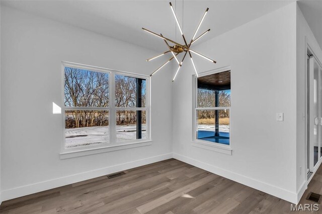 600 Legacy Dr, Waterloo, IL 62298 - empty room featuring a chandelier, wood finished floors, healthy amount of natural light, and baseboards