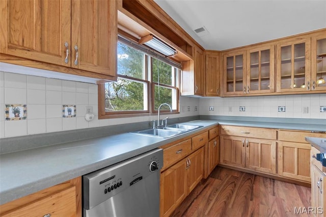 520 Christopher Dr, Perryville, MO 63775 - kitchen featuring dishwasher, a sink, dark wood-type flooring, decorative backsplash, and glass insert cabinets