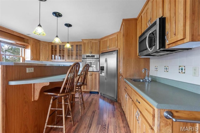 520 Christopher Dr, Perryville, MO 63775 - kitchen featuring stainless steel appliances, a sink, glass insert cabinets, backsplash, and a breakfast bar
