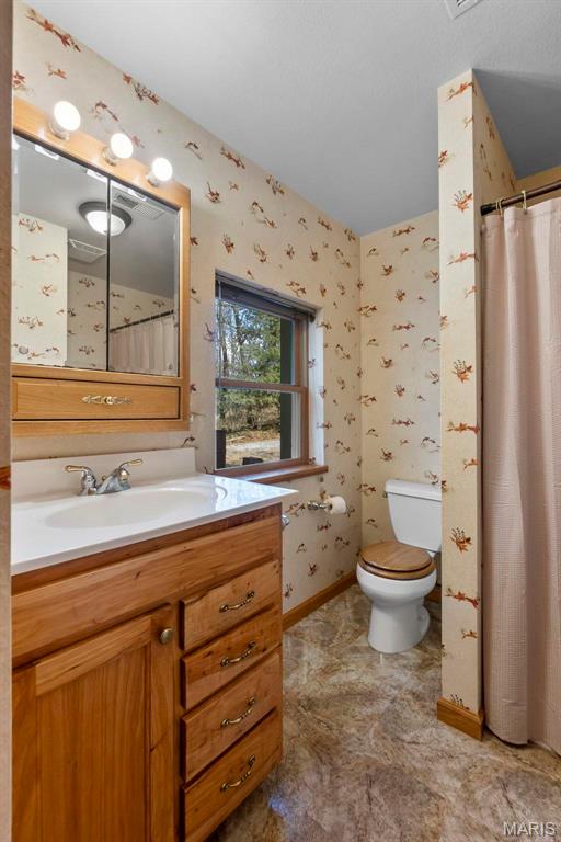 520 Christopher Dr, Perryville, MO 63775 - bathroom featuring vanity, wallpapered walls, toilet, baseboards, and a shower with shower curtain