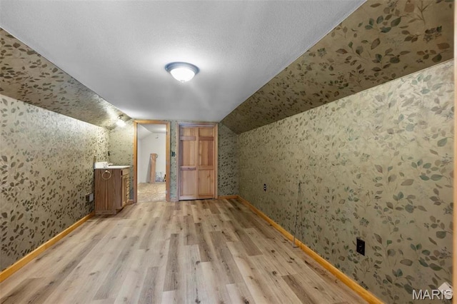 520 Christopher Dr, Perryville, MO 63775 - bonus room with wallpapered walls, light wood-type flooring, vaulted ceiling, and baseboards