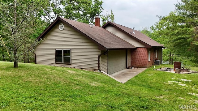 520 Christopher Dr, Perryville, MO 63775 - back of house with a chimney, a lawn, a shingled roof, central AC, and an attached garage