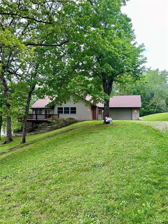 520 Christopher Dr, Perryville, MO 63775 - view of green lawn featuring an attached garage and a wooden deck