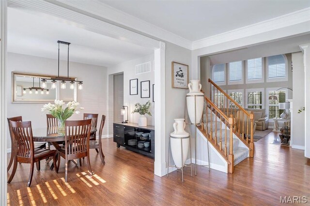 997 Sheffield Forest Ct, Wildwood, MO 63021 - dining space featuring wood finished floors, baseboards, stairs, and crown molding
