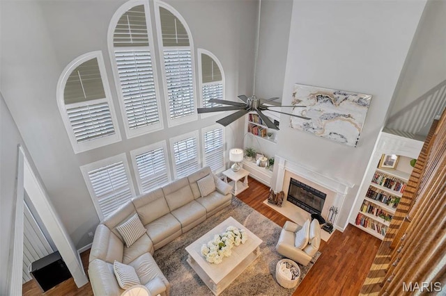 997 Sheffield Forest Ct, Wildwood, MO 63021 - living room with a high ceiling, ceiling fan, a fireplace, and wood finished floors