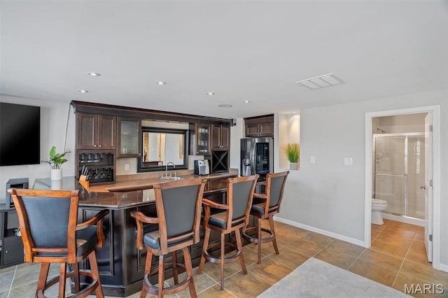 997 Sheffield Forest Ct, Wildwood, MO 63021 - kitchen featuring a sink, dark brown cabinets, stainless steel fridge with ice dispenser, a breakfast bar area, and recessed lighting