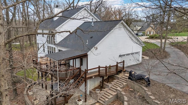 997 Sheffield Forest Ct, Wildwood, MO 63021 - view of property exterior with roof with shingles, a deck, driveway, stairway, and a chimney
