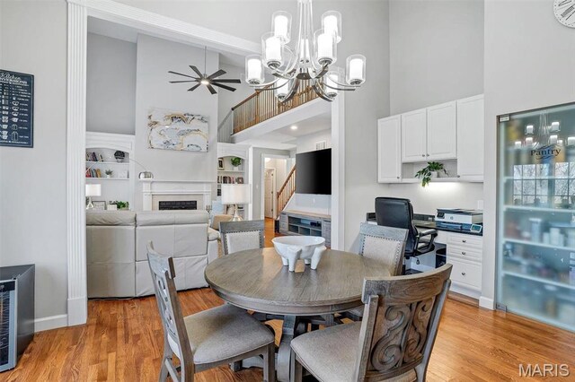 997 Sheffield Forest Ct, Wildwood, MO 63021 - dining room with high vaulted ceiling, a fireplace, a chandelier, light wood-type flooring, and built in features