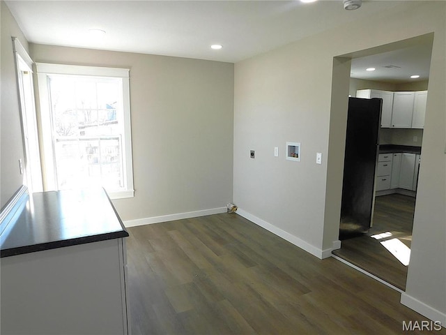 unfurnished dining area featuring dark wood finished floors, baseboards, and recessed lighting