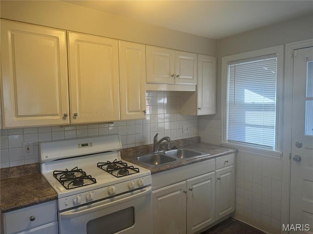 9100 Gedde Ave, Saint Louis, MO 63134 - kitchen with white gas stove, a sink, white cabinets, and tasteful backsplash