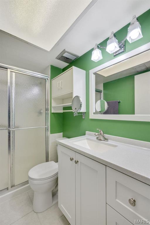 13485 Coliseum Dr Unit G, Chesterfield, MO 63017 - bathroom with vanity, toilet, a stall shower, and tile patterned floors