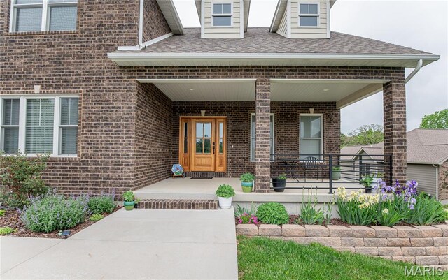 1201 Aster Ct, St James, MO 65559 - view of exterior entry with covered porch, brick siding, and roof with shingles