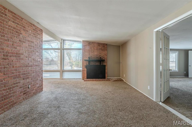 5 Little Ln, Florissant, MO 63033 - unfurnished living room with carpet floors, a fireplace, brick wall, and baseboards