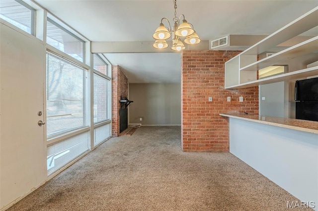 5 Little Ln, Florissant, MO 63033 - unfurnished living room with carpet floors, a chandelier, a fireplace, brick wall, and baseboards