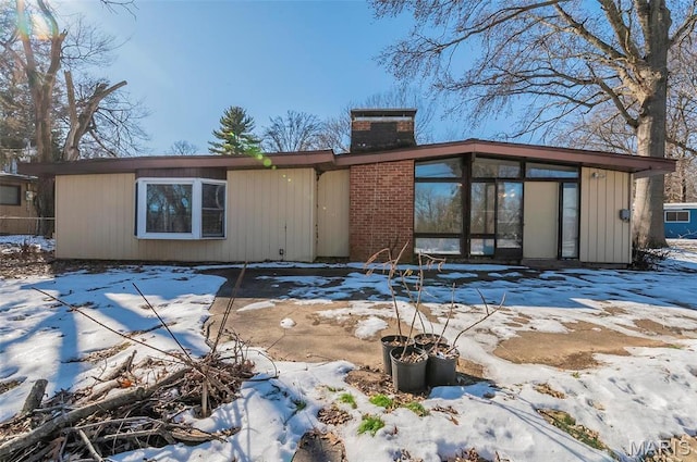 5 Little Ln, Florissant, MO 63033 - snow covered rear of property with a chimney