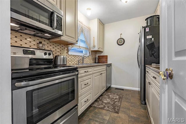 13459 Coliseum Dr, Chesterfield, MO 63017 - kitchen featuring appliances with stainless steel finishes, backsplash, cream cabinets, and dark stone finish flooring