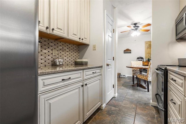 13459 Coliseum Dr, Chesterfield, MO 63017 - kitchen featuring appliances with stainless steel finishes, backsplash, stone finish floors, ceiling fan, and light stone countertops