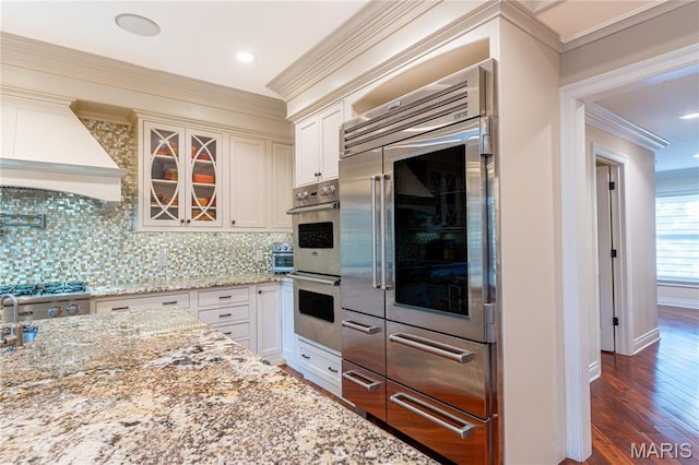 16 Holiday Ln, Saint Louis, MO 63131 - kitchen with appliances with stainless steel finishes, ornamental molding, light stone counters, backsplash, and white cabinetry