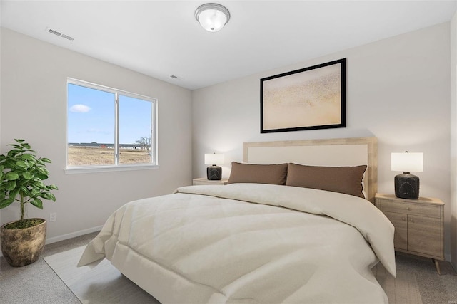 bedroom with light colored carpet and baseboards