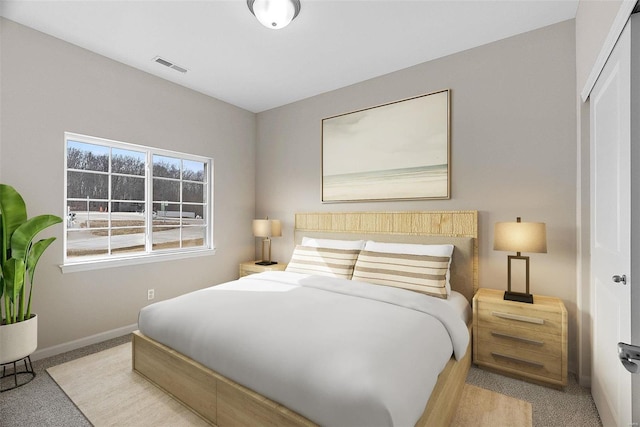 bedroom with light colored carpet, baseboards, and a closet