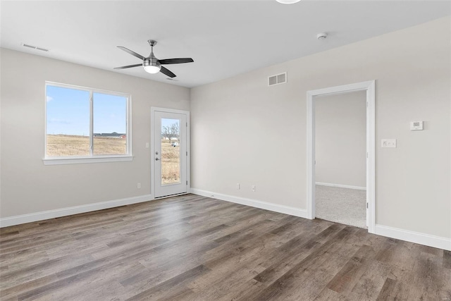 spare room featuring ceiling fan, wood finished floors, baseboards, and a smoke detector