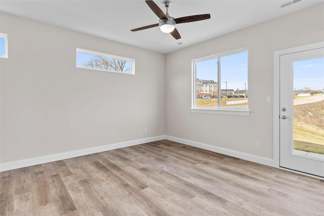 empty room featuring wood finished floors, baseboards, and a ceiling fan