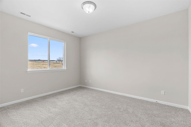 spare room featuring baseboards and carpet