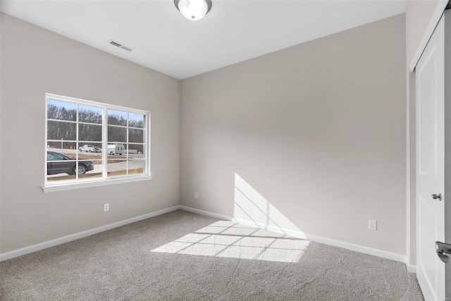 spare room featuring carpet flooring and baseboards