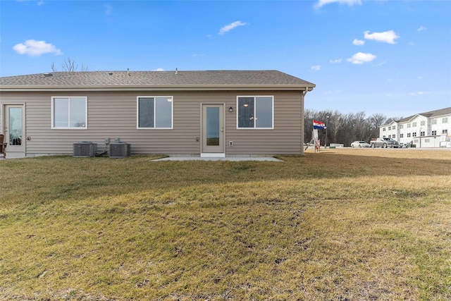 rear view of property with a yard and central AC