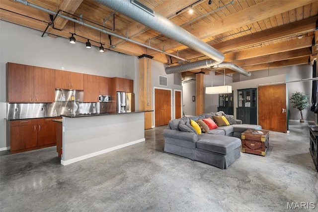 901 Washington Ave Unit 304, Saint Louis, MO 63101 - living area featuring rail lighting, finished concrete floors, a wooden ceiling with exposed beams, and a towering ceiling