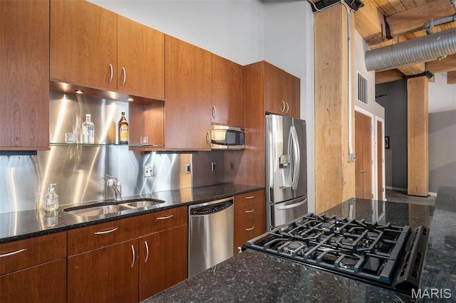901 Washington Ave Unit 304, Saint Louis, MO 63101 - kitchen with stainless steel appliances, dark stone counters, brown cabinetry, and decorative backsplash