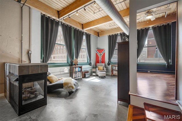 901 Washington Ave Unit 304, Saint Louis, MO 63101 - living area with healthy amount of natural light, rail lighting, a wooden ceiling with exposed beams, and concrete floors