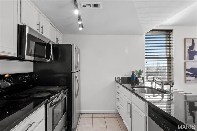 704 Soulard St Unit 704, Saint Louis, MO 63104 - kitchen featuring stainless steel appliances, a sink, light tile patterned floors, and white cabinets