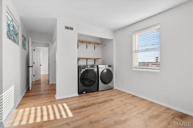 704 Soulard St Unit 704, Saint Louis, MO 63104 - washroom featuring washing machine and dryer, light wood-style floors, and baseboards