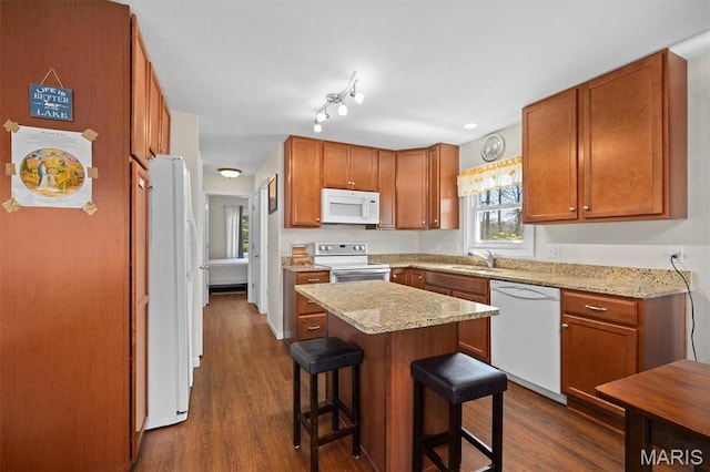 10949 Clearwater Ln, Plainview, IL 62685 - kitchen featuring white appliances, a kitchen breakfast bar, a sink, a center island, and brown cabinetry