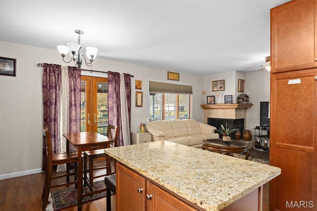 10949 Clearwater Ln, Plainview, IL 62685 - kitchen featuring dark wood-style flooring, a fireplace, light stone countertops, a chandelier, and a kitchen island