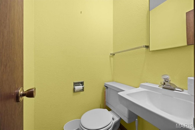 10949 Clearwater Ln, Plainview, IL 62685 - half bathroom featuring a sink, toilet, and a textured wall
