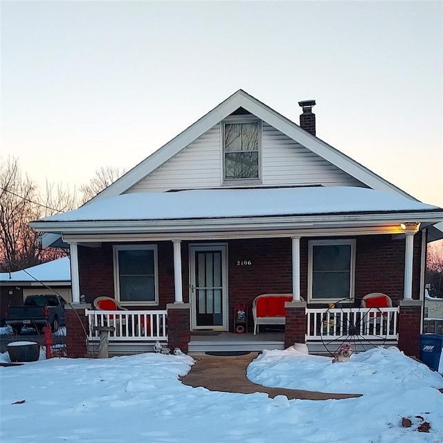 2106 Lackland Rd, Saint Louis, MO 63114 - view of front of house featuring covered porch, a chimney, and brick siding