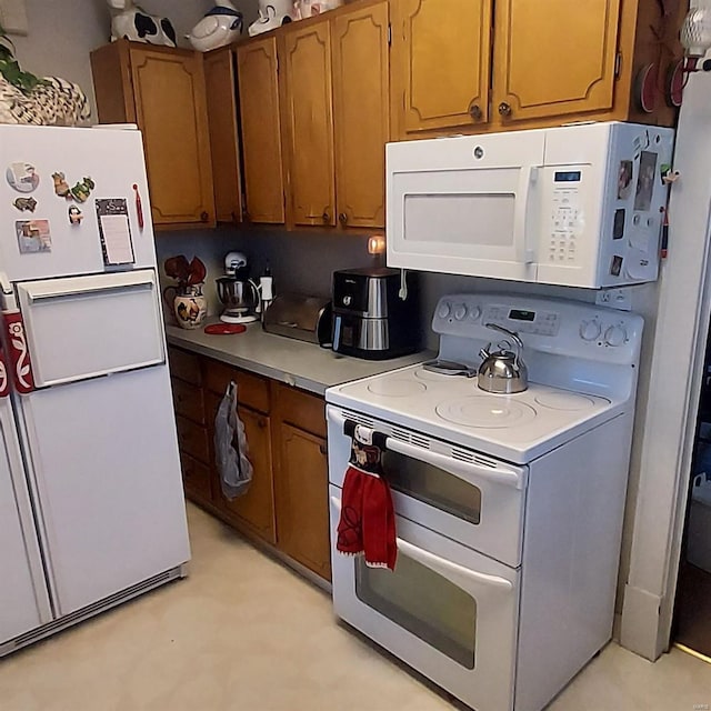 2106 Lackland Rd, Saint Louis, MO 63114 - kitchen with white appliances, brown cabinets, light countertops, and light flooring